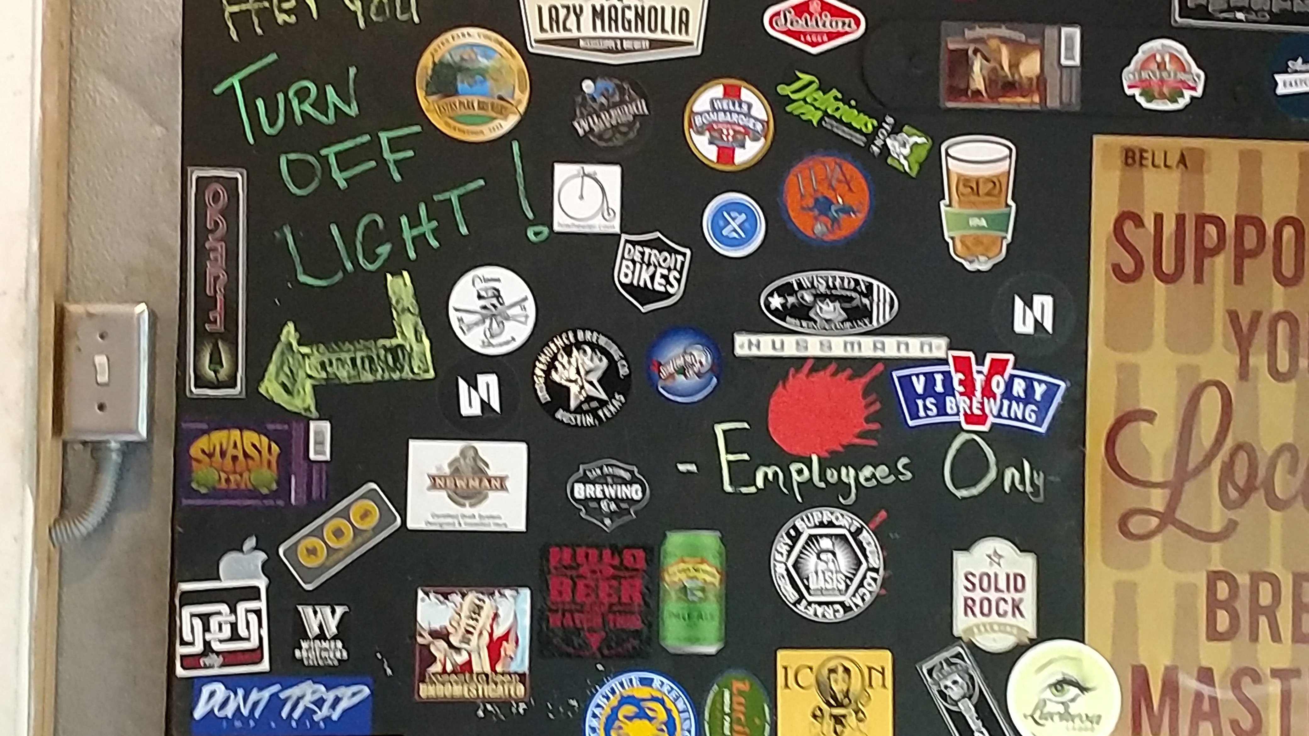 Back wall with stickers from local neighborhood bar