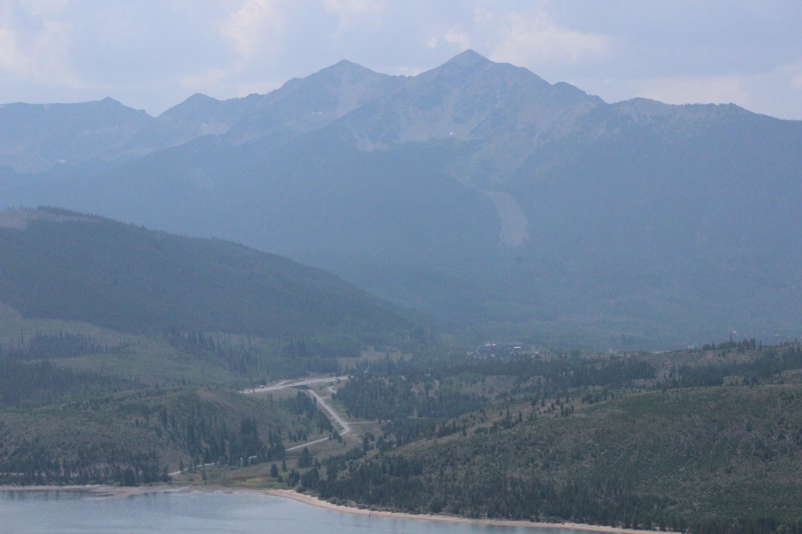 Mountain range with treeline against blue sky