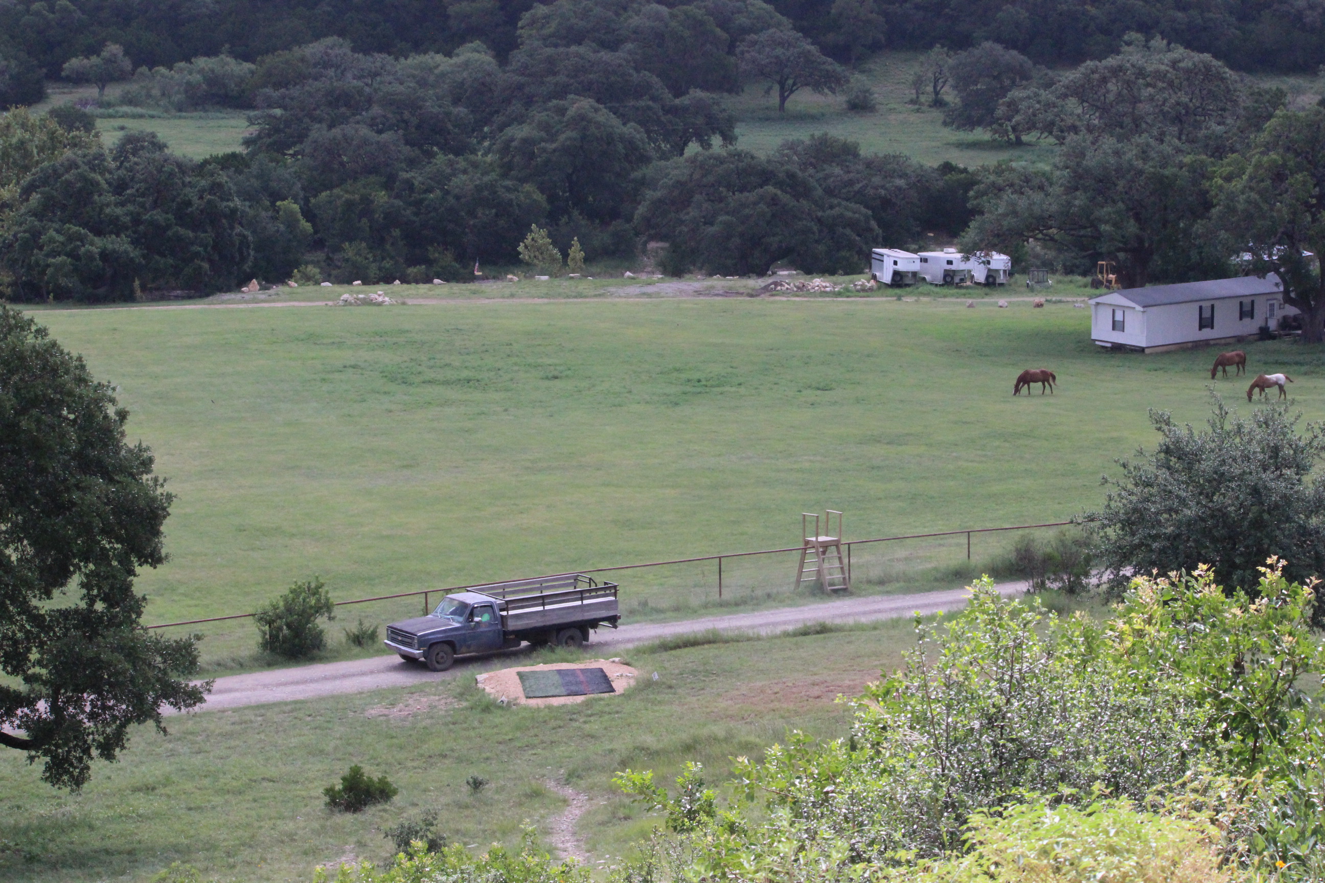 Hillside view of small field with passing truck